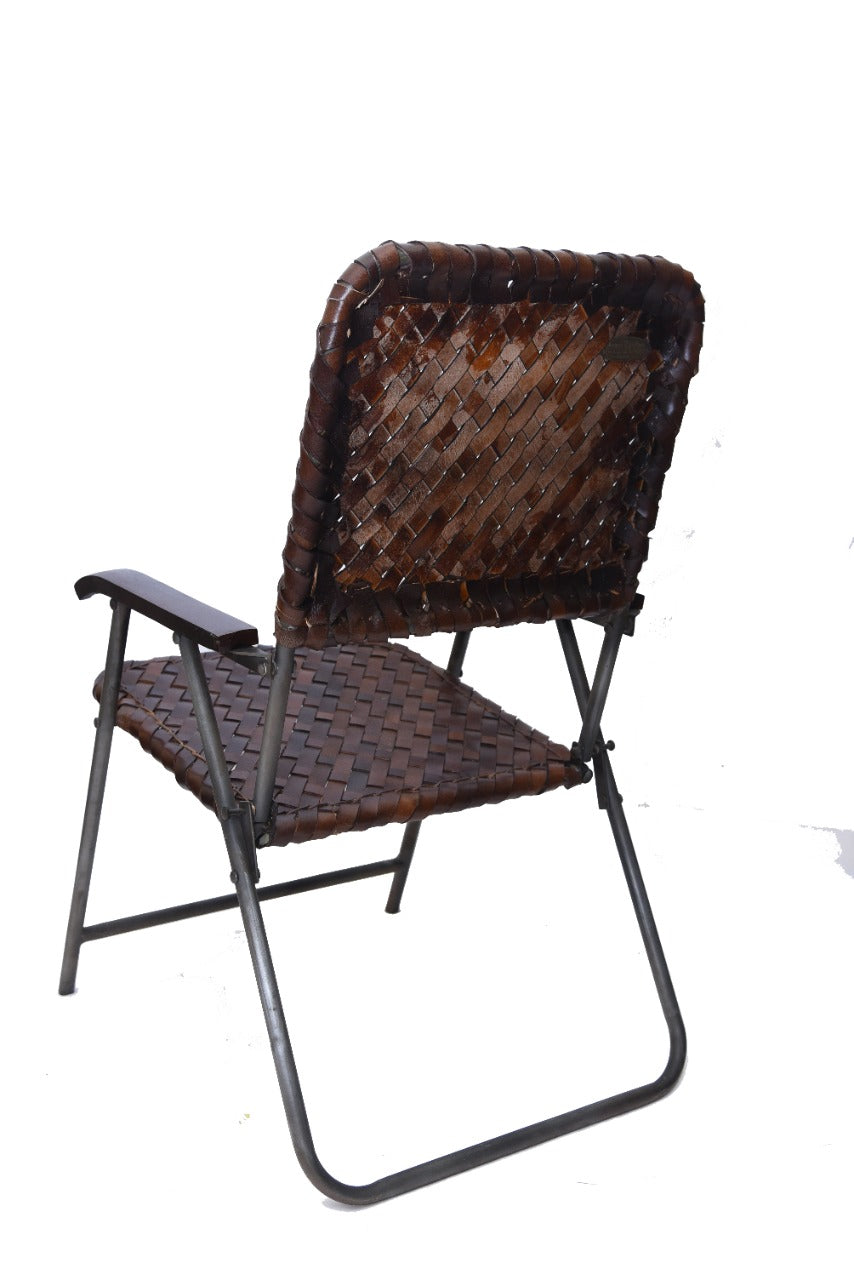 Back view of a woven leather sling chair.