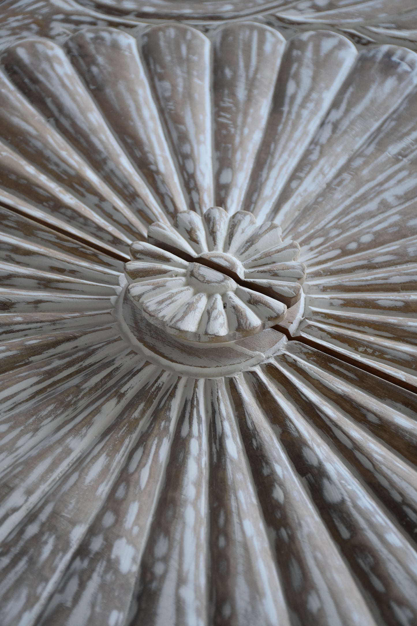 Close-up of detailed carved wood design on media cabinet.