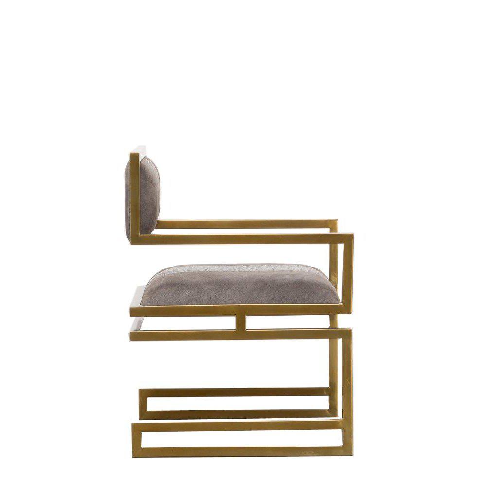 Side view of a sleek designer chair with a gold base.