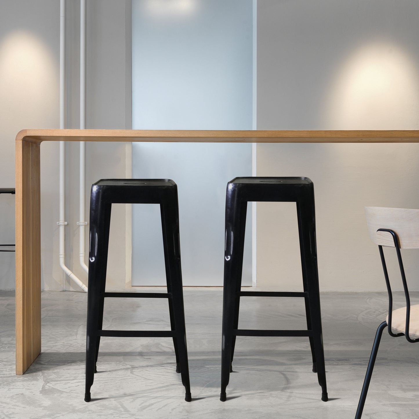 Pair of black bar stools in a bright interior space.