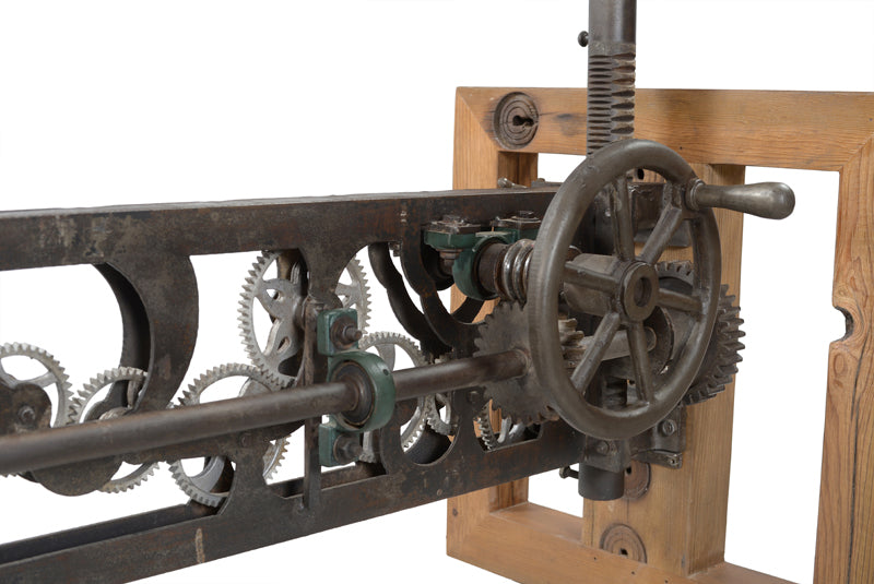 Close-up view of dining table’s iron gear mechanism.