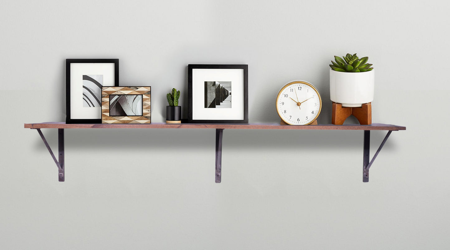 Wooden shelf styled with frames and small décor items.