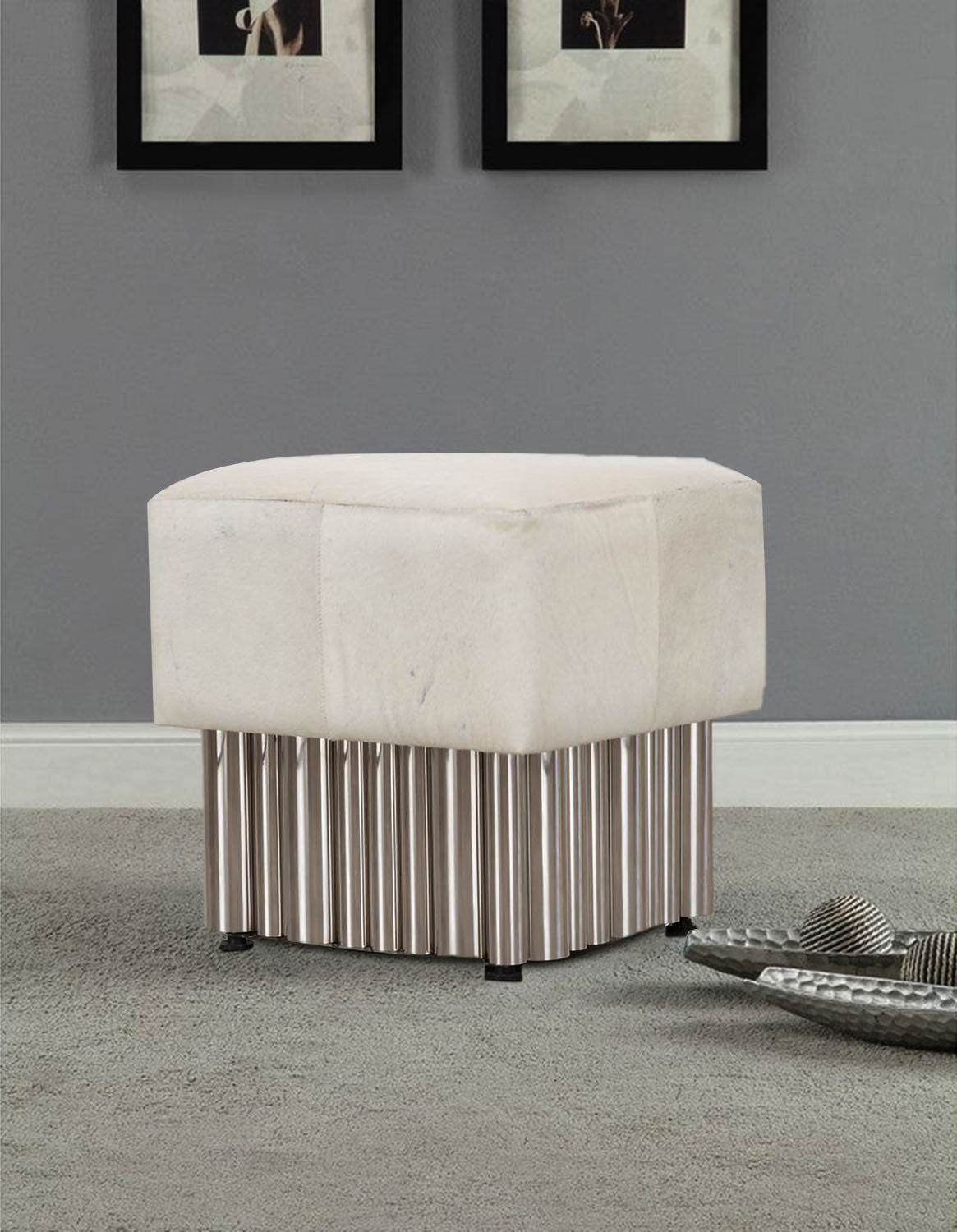 White leather ottoman with a stainless steel base in a living room.